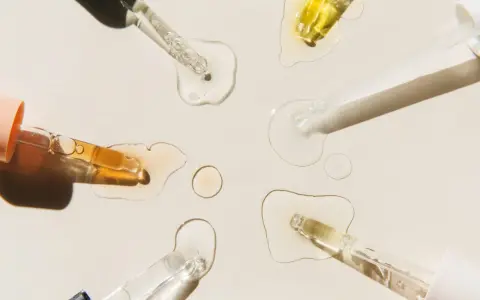 Krople serum i pipetki na jasnym tle.