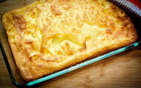 En gyllene, fluffig ugnspannkaka i en glasform, redo att serveras. Ett perfekt ugnspannkaka recept för en mysig middag.