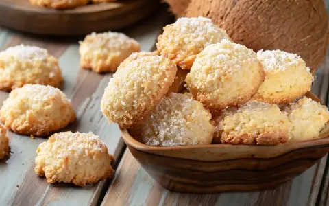 Pyszne ciasteczka keto z mąki kokosowej, posypane wiórkami, kuszą swoim wyglądem i zapachem. Idealne na dietę ketogeniczną.