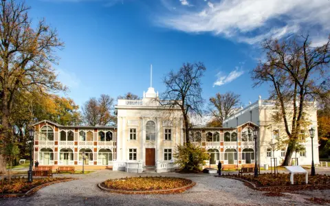 Brzeźno dom zdrojowy, zabytkowy budynek z arkadowymi werandami, otoczony jesiennym parkiem.
