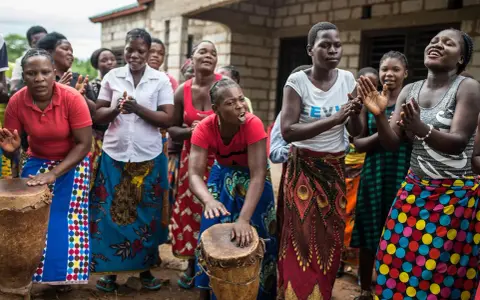 Des femmes africaines jouent du tambour et chantent, un parfait synonyme de sororité.