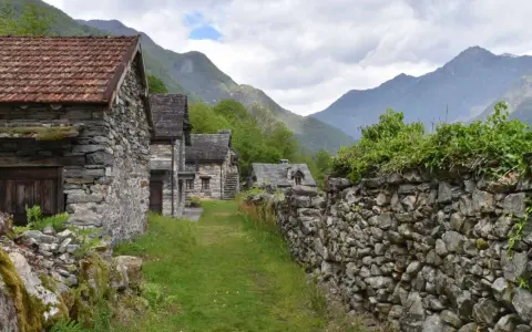 Steindörfer im Valle Maggia, umgeben von grünen Bergen und bewachsenen Mauern.