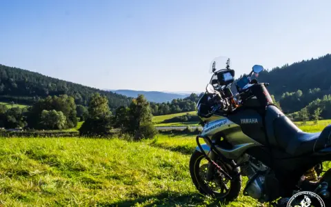 Motocykl Yamaha zaparkowany na łące, w tle malownicze wzgórza Bieszczad. Idealne miejsce na przejażdżkę pętlą bieszczadzką.