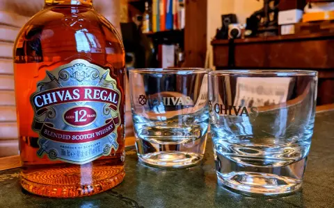 Chivas Regal 12 z czym pić? Butelka Chivas Regal 12 i dwa kieliszki, gotowe na degustację.