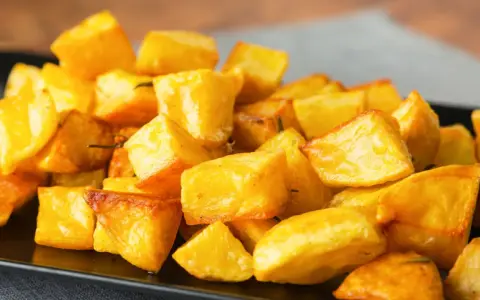 Un mucchio invitante di patate al forno croccanti, dorate e profumate, pronte per essere gustate.
