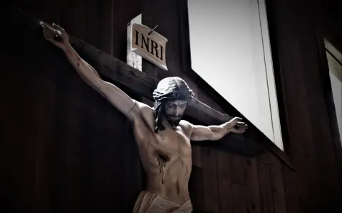 Ukrzyżowany Jezus z koroną cierniową i tabliczką INRI. Jego ciało jest blade, a z boku spływa krew.