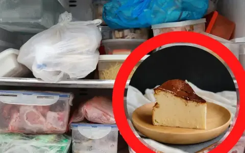 Kawałek pysznego sernika na talerzyku, otoczony mrożonkami w zamrażarce. Czy sernik można mrozic? Tak, ten wygląda na gotowego do zamrożenia.