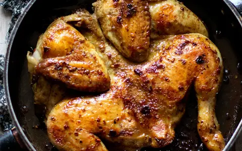 Pollo alla diavola dorato e succulento, cotto in padella con spezie piccanti.