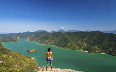 Frauenblick auf die grüne Bucht von Paraty, Brasilien, mit bewaldeten Bergen und Inseln.