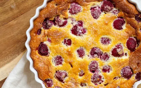 Un délicieux clafoutis framboise tout juste sorti du four, saupoudré de sucre glace. Parfait pour un goûter gourmand.