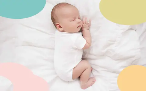 Un bebé duerme plácidamente sobre sábanas blancas. Es una imagen que evoca paz y nos hace pensar en cuando empiezan a dormir mejor los bebés.