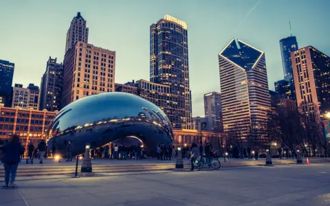 Reflections of the Chicago skyline shimmer on the iconic Cloud Gate sculpture. A perfect snapshot of Chicago in a day, with people enjoying the evening.
