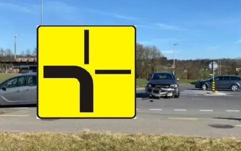 Znak drogi z pierwszeństwem przejazdu i uszkodzony samochód na skrzyżowaniu. Wypadek spowodowany łamanym pierwszeństwem.