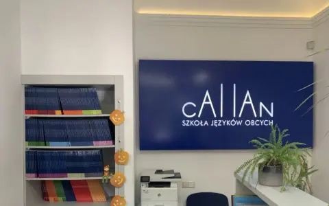 Szkoła językowa oferująca angielski metodą Callana. Na półkach książki, obok dynie. Na ścianie logo szkoły.