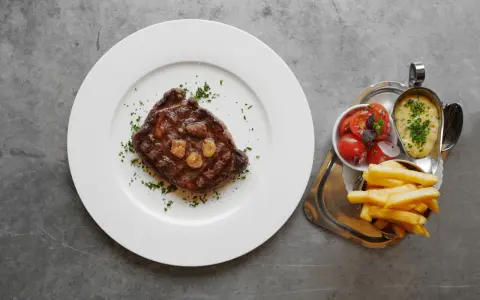 En saftig biff med vitlök, pommes frites, tomatsallad och bearnaisesås. En måltid som får en att vilja skriva restaurang Prinsens recensioner.