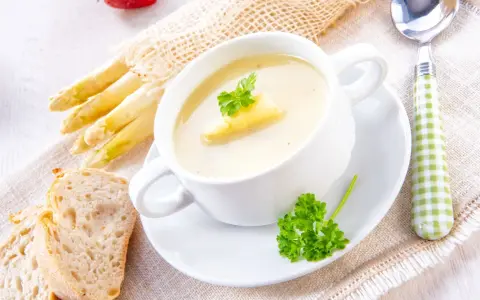 Cremige Spargelsuppe mit frischem Spargel, Brot und Petersilie. Ein köstliches Spargelsuppe Rezept für Genießer.
