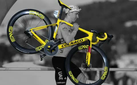 A cyclist carries his bright yellow Colnago bike, ready for Tour de France training.