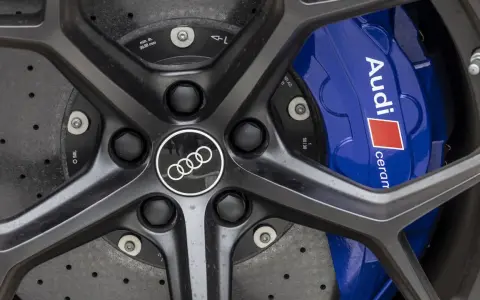 Primo piano di un cerchio Audi RS6 con pinze freno blu e logo Audi.