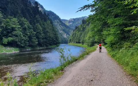 Rowerzystka na szlaku wzdłuż Dunajca. Malownicza trasa rowerowa w otoczeniu zielonych gór i rzeki. Biały Dunajec zachwyca.