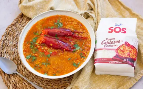 Un delicioso arroz caldoso con gambas rojas, adornado con perejil fresco. La bolsa de arroz SOS "Especial Caldosos y melosos" promete una preparación perfecta.