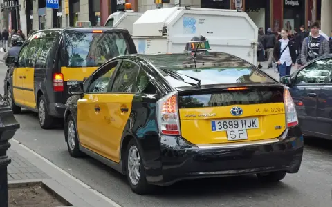 Gelbe Taxis in Barcelona, ein Toyota Prius und ein größeres Taxi XL, warten auf Fahrgäste.