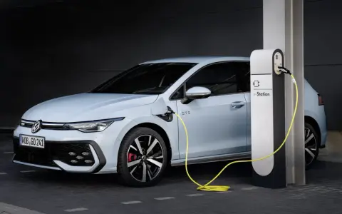 Jasnoniebieski Volkswagen Golf GTE podłączony do stacji ładowania e-Station.
