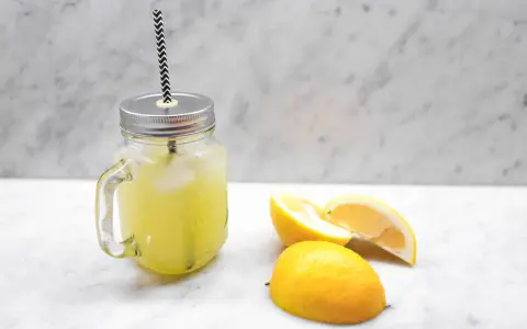 En burk med hemgjord lemonad, is och citronskivor. Perfekt för ett enkelt lemonad recept.