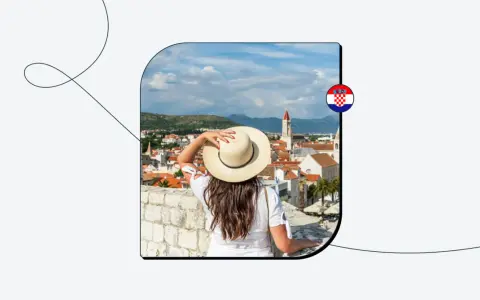 Kobieta w kapeluszu patrzy na chorwackie miasto z muru. Flaga Chorwacji.