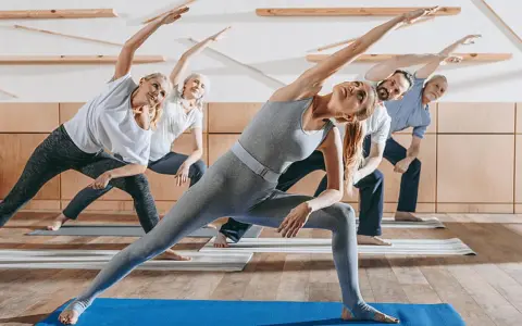 Menschen unterschiedlichen Alters üben Yoga. Sanfte Bewegungen wie diese sind ideal für Gymnastik bei Osteoporose, um Kraft und Gleichgewicht zu fördern.