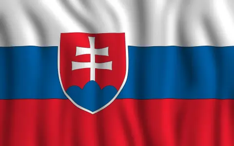 Flaga Słowacji powiewa na wietrze. Biało-niebiesko-czerwone pasy z godłem Słowacji po lewej stronie.
