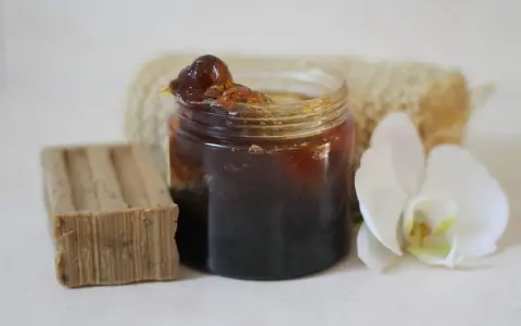 Un pot de savon noir, une barre de savon, une fleur d'orchidée et une éponge. Idéal pour un insecticide naturel à base de savon noir, bicarbonate et autres ingrédients.