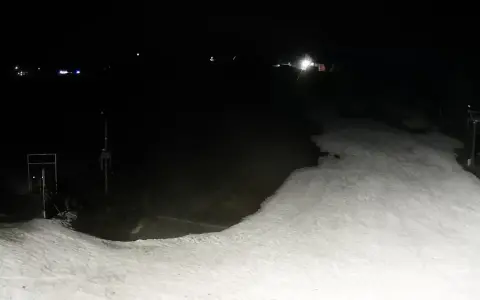 Nocne widoki z olczański wierch kamery. Ośnieżony stok i wyciąg narciarski w ciemności.