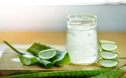 Tranches d'aloe vera et un verre rempli de sa pulpe translucide, évoquant les nombreux aloe vera bienfaits pour la santé et la peau.