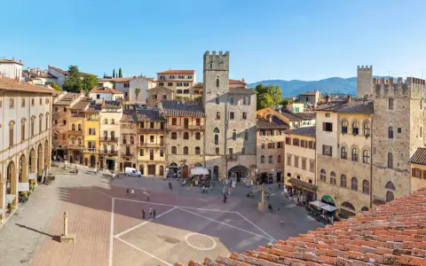 Piazza del Popolo ad Arezzo, con la torre medievale e i palazzi storici che incorniciano la piazza, un luogo incantevole nei dintorni.