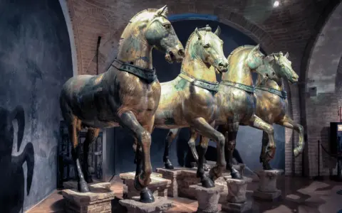 Les célèbres chevaux de Saint-Marc, statues de bronze patiné, se dressent fièrement dans un musée, leurs corps musclés capturant l'essence de la puissance antique.