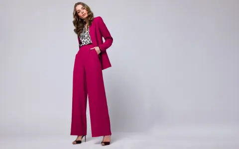 Elegancka stylizacja na chrzciny ze spodniami: fuksjowy garnitur z szerokimi nogawkami i bluzka w panterkę.