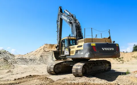 Koparka Volvo na placu budowy. Zastanawiasz się, ile kosztuje kurs na koparkę? Maszyna czeka na operatora.