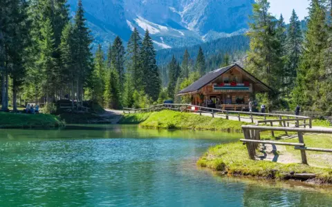 Rifugio alpino in Italia, con lago cristallino e montagne sullo sfondo. Perfetto per una vacanza in montagna Italia.