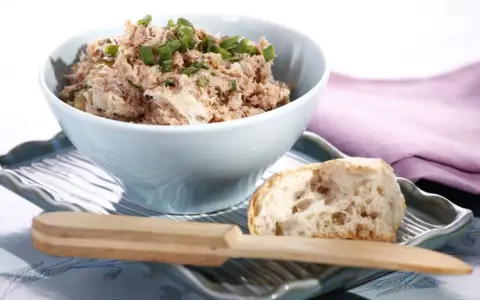 Pyszna pasta z tuńczyka i jajka, posypana szczypiorkiem, podana z kawałkiem chleba. Idealna na szybką przekąskę.