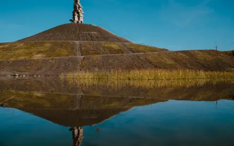 Die Himmelstreppe Gelsenkirchen spiegelt sich im Wasser. Ein Kunstwerk auf einer Halde.