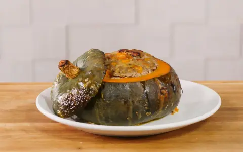 Deliziosa zucca ripiena, con un appetitoso ripieno dorato che fuoriesce dal suo guscio cotto.