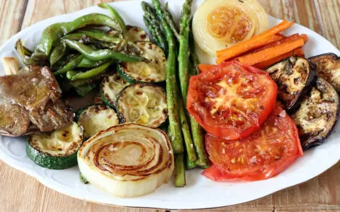 Plato de verduras a la plancha: pimientos verdes, calabacín, espárragos, zanahorias, cebolla, tomate y berenjena, todo asado a la perfección.