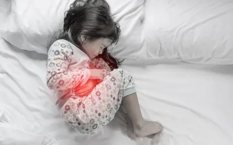 Dziecko z bólem brzucha, czerwony obszar wskazuje na problem. Czy Coca-Cola pomoże w leczeniu rotawirusa?
