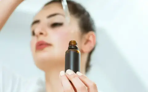 Kobieta aplikuje serum na twarz. Odkryj zachwycające ozonowanie twarzy efekty dla promiennej cery.