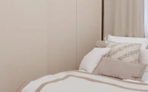 Sovrumsinspiration med en stor, ljus garderob och en inbjudande säng med många kuddar.