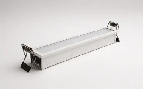 Une réglette led encastrable blanche avec des ressorts métalliques pour l'installation.