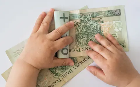 Dziecko bawi się banknotami 100 zł. Czy to już 12 tys na dziecko?