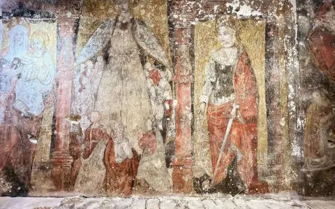 Fresque dégradée, exemple de l'art de la Renaissance, montrant des figures religieuses, dont une Vierge à l'Enfant et une sainte armée d'une épée.