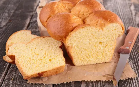 Brioche dorée, moelleuse et aérienne, parfaite pour une recette brioche machine à pain. Tranchée, elle révèle sa mie tendre.