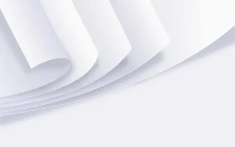 Stos białych kartek papieru zwiniętych w rogu.